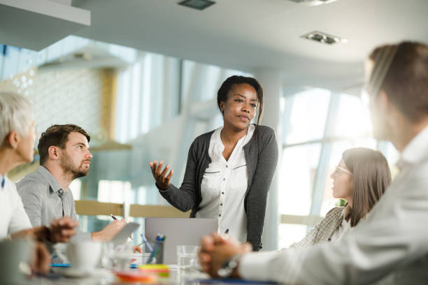 istock African American CEO talking to her team in the office. 2204664611