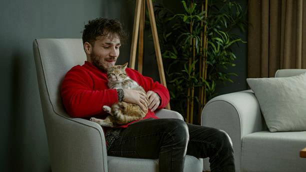 istock Young Man Cuddling His Cat in a Cozy Home 2204664823