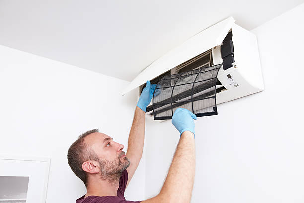 istock Man cleaning and maintaining air condition unit at home. 2204665621