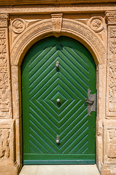 Old green wooden door on ancient stone building.