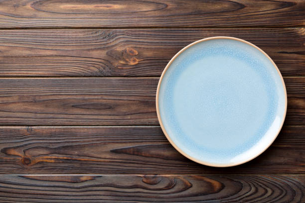 istock Top view of empty blue plate on wooden background. Empty space for your design 2204666661
