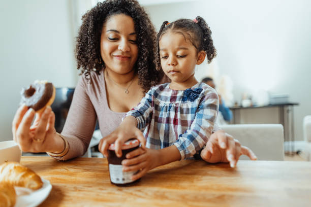 Family with two little daughters enjoying breakfast together
