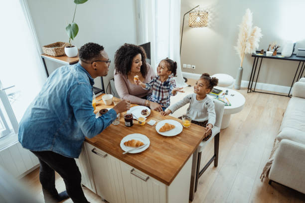 Family with two little daughters enjoying breakfast together