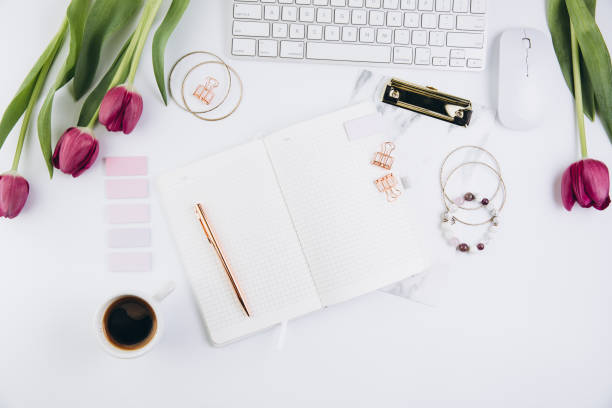 istock Flat lay, top view office table desk frame. Feminine desk workspace with succulent, laptop, glasses, diary and golden clips on white background 2204672450