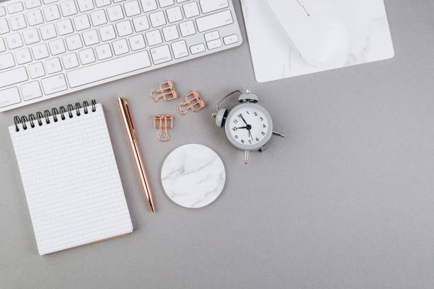 istock Grey office desk table with blank notebook, computer keyboard and other office supplies. Top view with copy space, flat lay 2204672563
