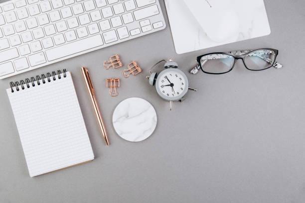 istock Grey office desk table with blank notebook, computer keyboard and other office supplies. Top view with copy space, flat lay 2204672567