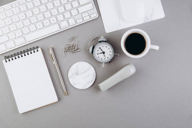 istock Grey office desk table with blank notebook, computer keyboard and other office supplies. Top view with copy space, flat lay 2204672611