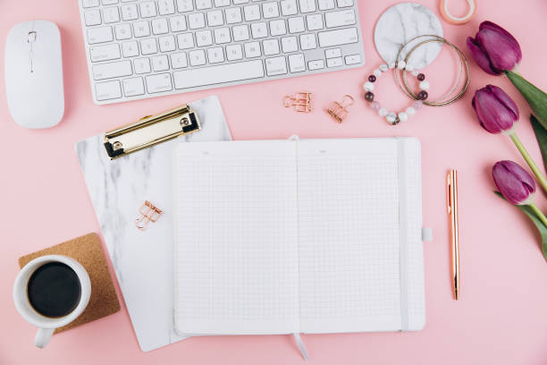 istock Flat lay, top view office table desk frame. Feminine desk workspace with succulent, laptop, glasses, diary and golden clips on pink background 2204672649