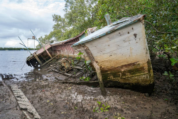 An old wooden boat abandoned on the waters edge slowly decaying away