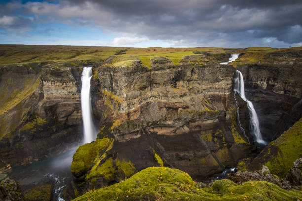 istock Majestic water cascades flowing down rugged cliffs in Iceland under a dramatic sky 2204673755