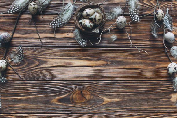 istock Decoration with quail eggs, nest and feathers. Wooden background with sample text Happy Easter 2204674121