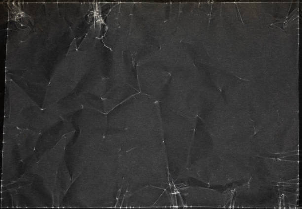 istock Crumpled black paper texture highlighted in soft light, perfect for background use in artistic projects or design work 2204674883