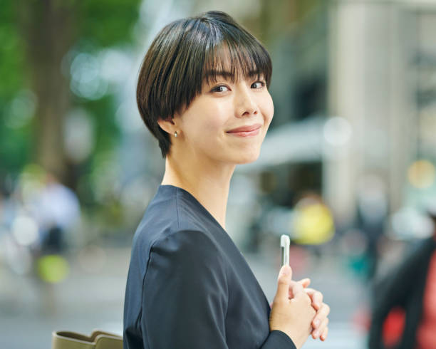 istock A smiling 30-something female office worker checking her smartphone on the street 2204675014