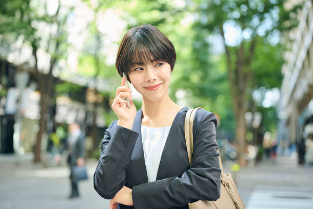 istock A smiling 30-something female office worker checking her smartphone on the street 2204675564