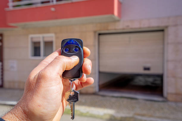 White person's hand holding garage door opener