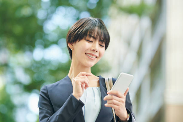 istock A smiling 30-something female office worker checking her smartphone on the street 2204676255
