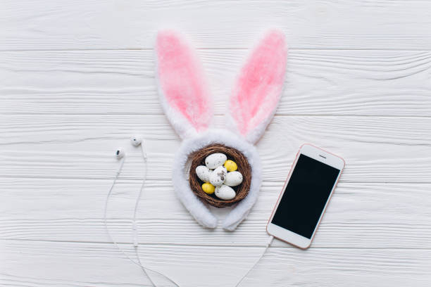 istock Happy Easter. Egg in a nest. Ears of a rabbit with smartphone. Top view. 2204676357