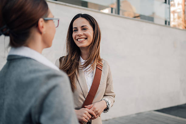 istock Two businesswomen talking and smiling outside office building 2204678469