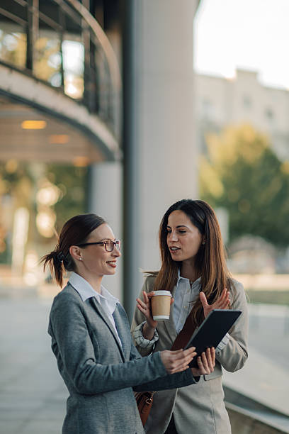 istock Businesswomen discussing work using digital tablet outdoors 2204678572