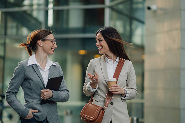istock Two businesswomen walking and talking outside office building 2204678574