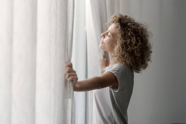 Serene woman waking up and looking out the window