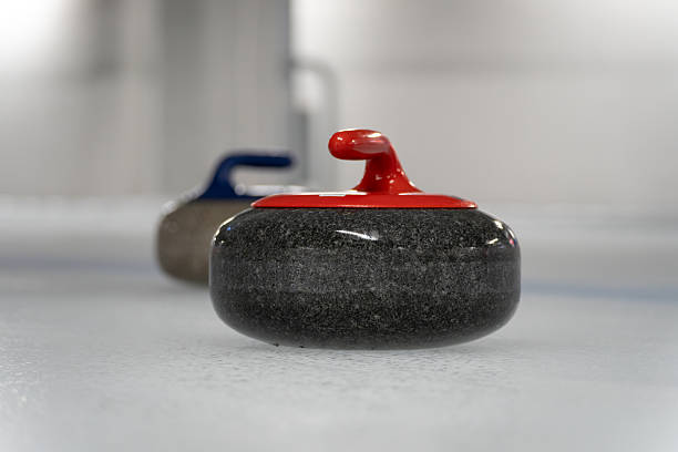 istock Curling stones on the ice rink sheet. Polished and shaped granite rocks with a handle on top, used to play the game of curling. 2204680347