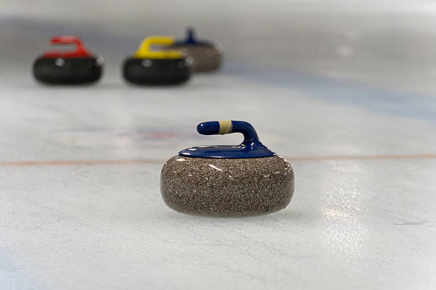 A close-up view of a red faceoff circle on a perfectly maintained ice rink, with the smooth surface reflecting the arena lights. The vibrant red markings contrast sharply against the white ice, ready for the next hockey game.