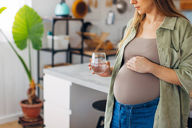 istock An unrecognizable pregnant woman drinks vitamins and hydrates herself while standing at the kitchen counter in a modern apartment 2204684597
