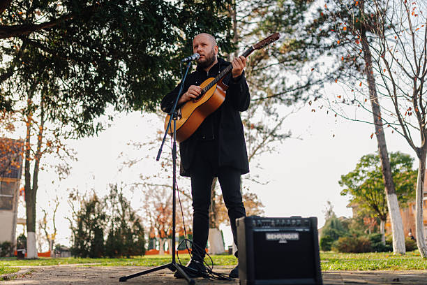 istock Musician playing acoustic guitar and singing in a park 2204684802