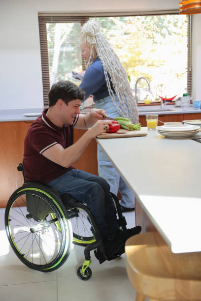 istock Disabled man and woman preparing food in kitchen 2204684878