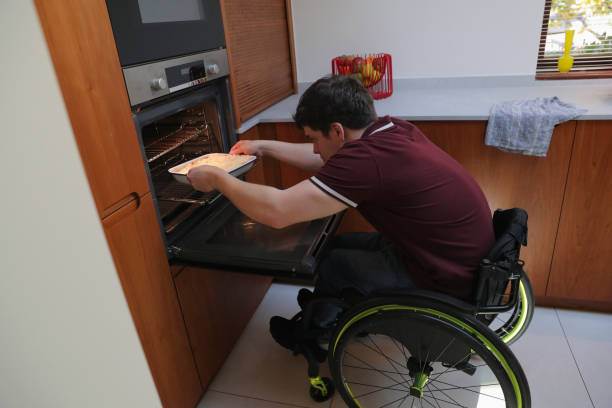 istock Man in wheelchair baking in kitchen 2204684892