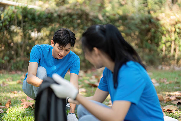 istock Focused teamwork. Volunteers collaborating in park cleanup. 2204684893