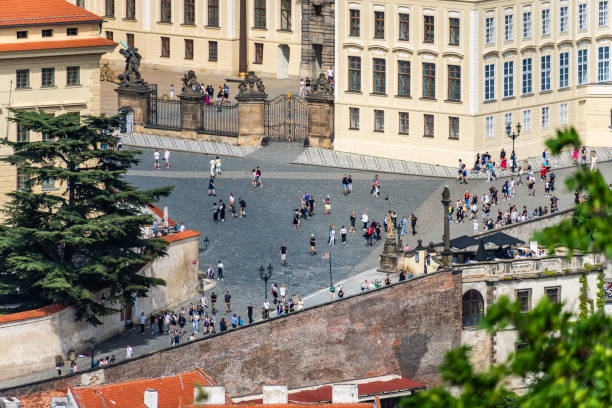 Tourists walking in prague castle square on a sunny summer day