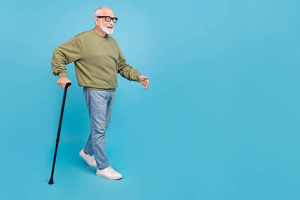 istock Full length body size view of attractive cheerful grey-haired man using cane strolling copy space isolated over bright blue color background 2204686348