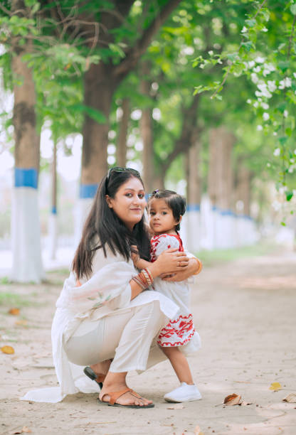 istock Mother Embracing Her Young Daughter in a Park 2204687669