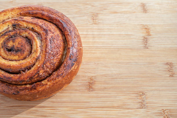 Cinnamon roll. Sweet desert, classic pastry look on a wooden background for menu or bakery use. Top view, flat lay