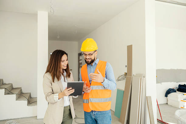 istock Smiling architect and interior designer collaborating on a project while standing in house in building process. 2204689475