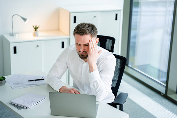 istock Stressed Businessman Working on Laptop in Modern Office Setting 2204689773