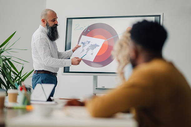 istock Businessman leading a presentation with global map and target market analysis in modern office 2204690877