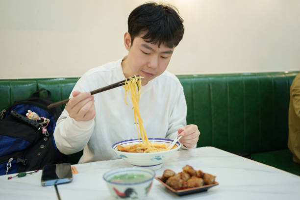 istock Asian man enjoying satay noodles 2204695916