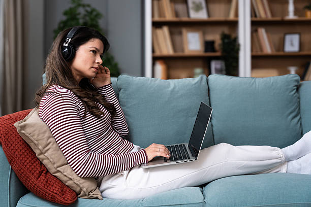 istock Young beautiful business woman lying on couch using laptop computer in home office apartment, working online, having video call for e-commerce, online course and education, e-learning, work routine. 2204696355