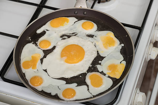 istock Chicken egg and 9 quail eggs in frying pan. 2204696738