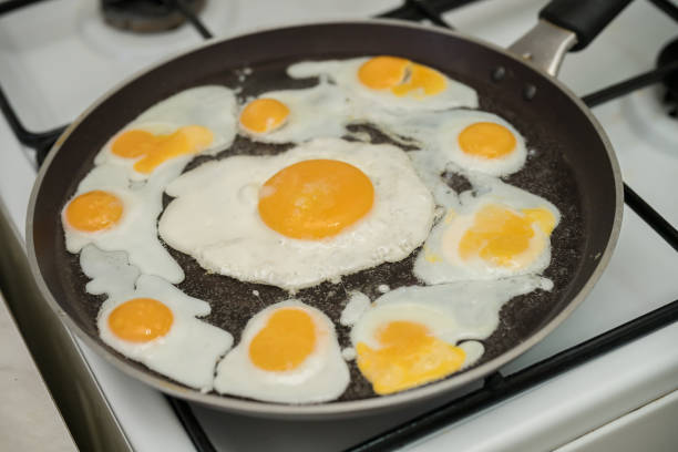 istock Chicken egg and 9 quail eggs in frying pan. 2204696942