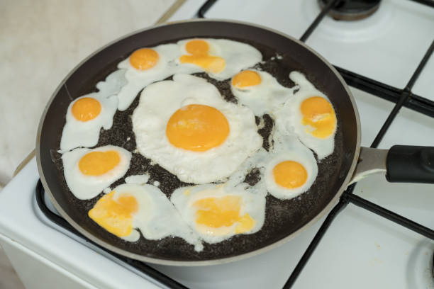 istock Chicken egg and 9 quail eggs in frying pan. 2204696985