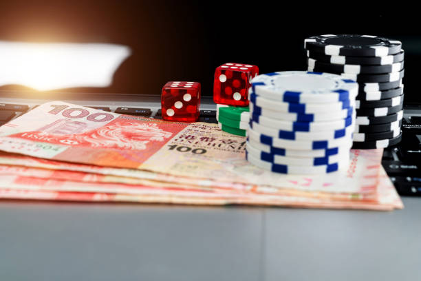 istock Gambling chips and Hong Kong currency on laptop keyboard 2204697603