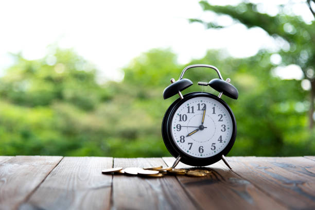 Alarm clock and coins on the table