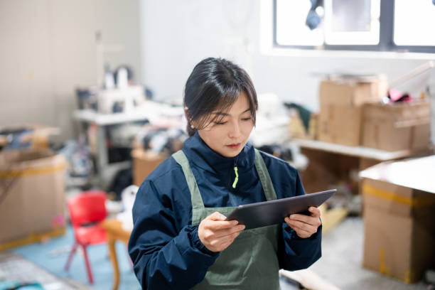 istock Asian female blue-collar workers are using tablets in the sewing workshop. 2204698530