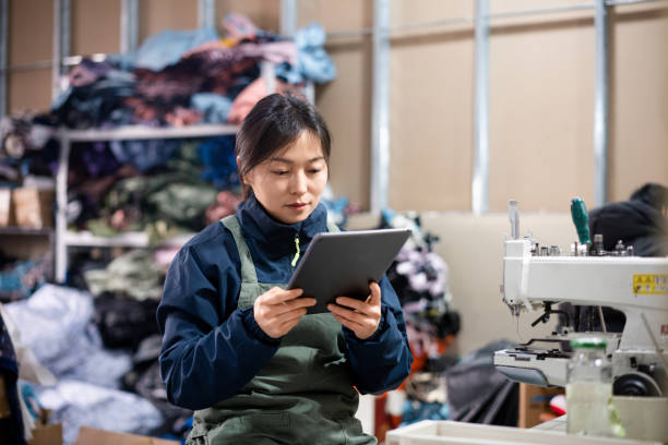 istock Asian female blue-collar workers are using tablets in the sewing workshop. 2204698568