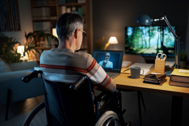istock Man in wheelchair having a video call at home 2204699036