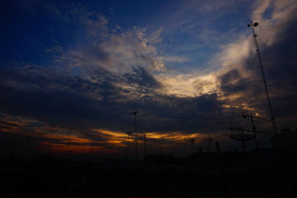 Dramatic sunset sky with clouds and silhouettes. A vibrant blue sky with fluffy white clouds